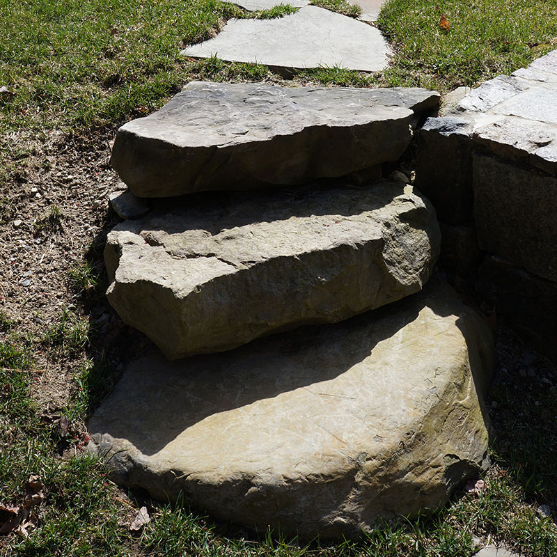 outdoor steps made out of stone steppers surrounded by green grass